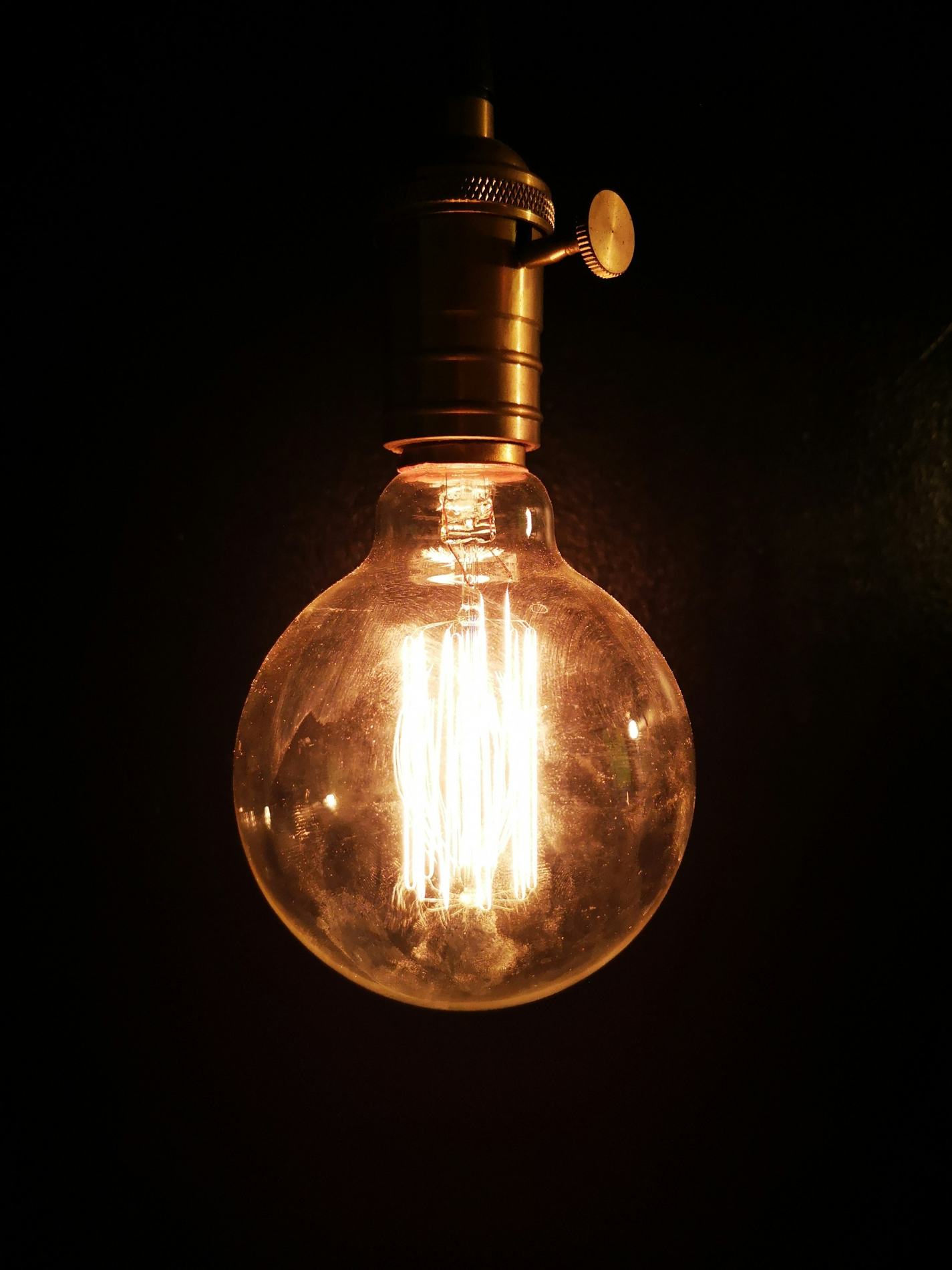 A warm filament bulb against the dark