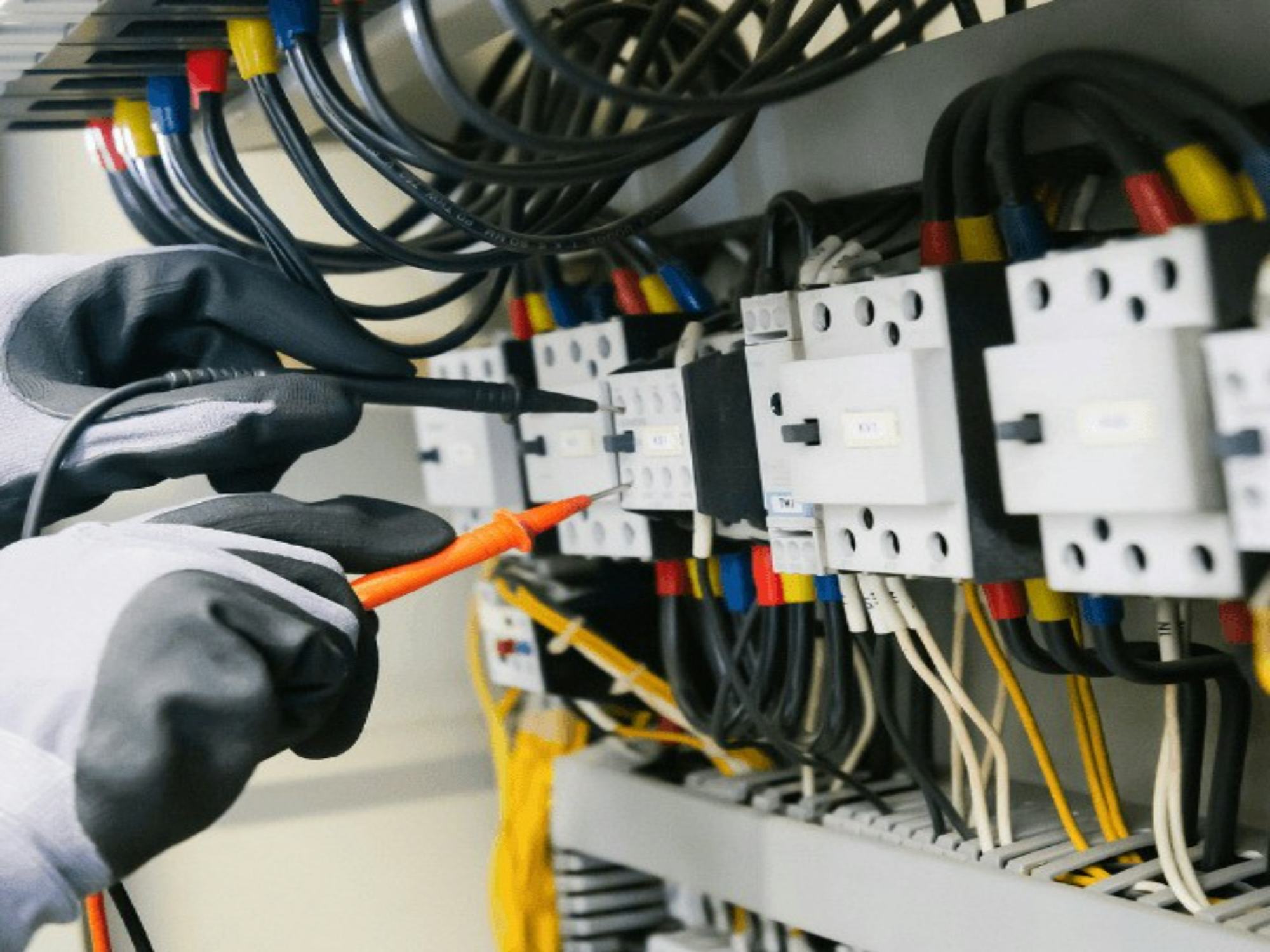 An electrician working inside a switchboard